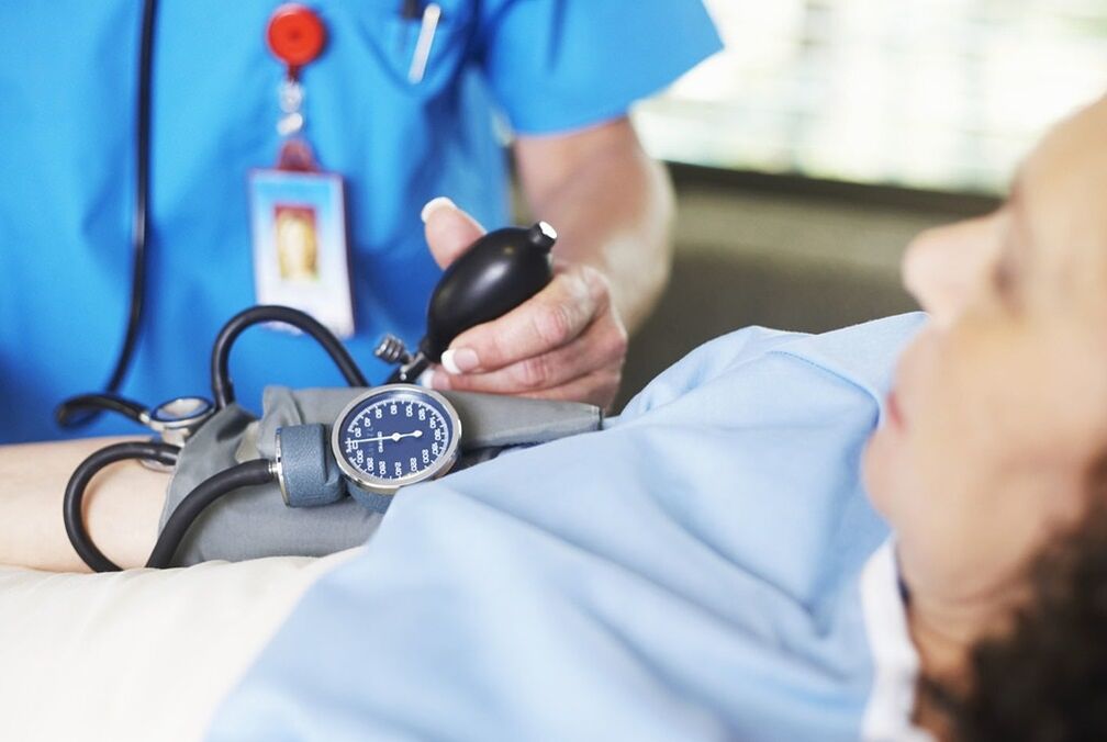 O médico mide a presión do paciente con presión arterial alta